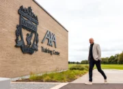 Arne Slot berdiri di area AXA Training Centre Liverpool
