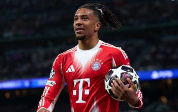 Michael Olise memegang bola Liga Champions bersama Bayern Munchen