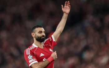 Mohamed Salah mengangkat tangan dalam jersey Liverpool pada momen pengumuman perpisahan