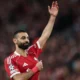 Mohamed Salah mengangkat tangan dalam jersey Liverpool pada momen pengumuman perpisahan